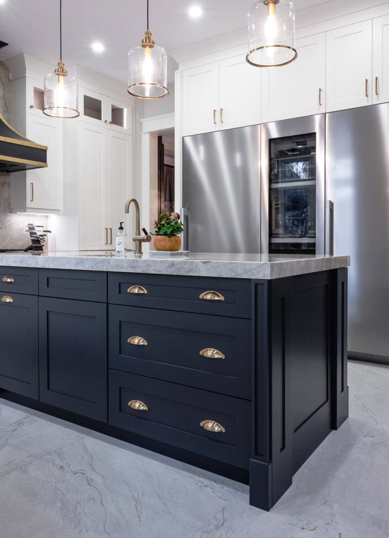 Antique bronze bin pulls centered on dark lower kitchen drawers