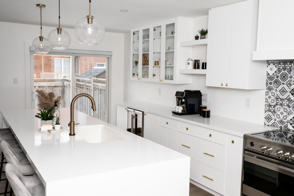 Brushed metal round knobs on white upper kitchen cabinet doors
